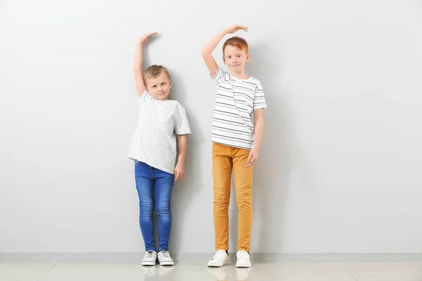 Carino Bambini Che Misurano Altezza Vicino Alla Parete Luminosa — Foto Stock