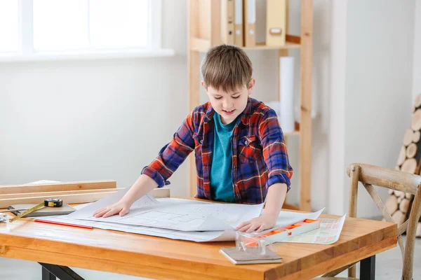 Cute little builder with drawings in room