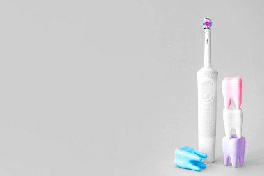 Elektrikli diş fırçaları ve arka planda plastik dişler.
