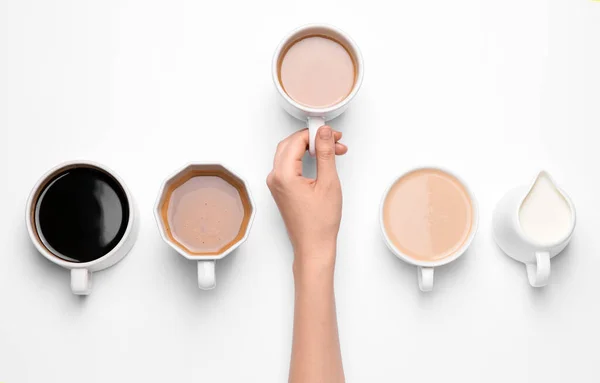 女性の手と白い背景に異なるコーヒーのカップ — ストック写真