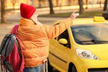 Şehir caddesinde taksiye binen bir turist