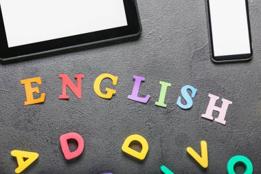 Gri arkaplan üzerinde modern aygıtlar ve metin ENGLISH bileşimi