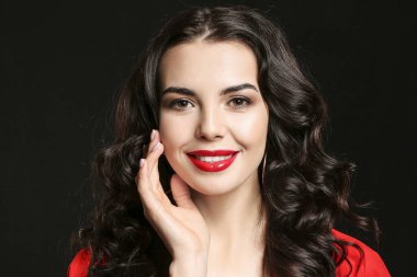 Siyah arka planda güzel makyajlı genç bir kadın.