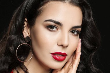 Siyah arka planda güzel makyajlı genç bir kadın.