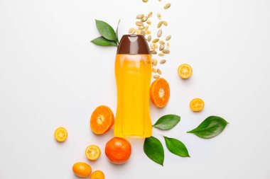 Bottle of shampoo and citrus fruits on white background clipart