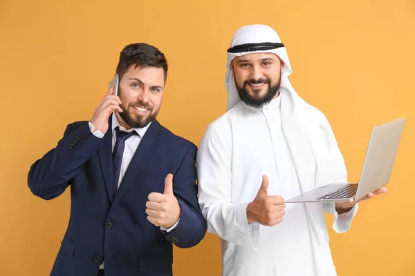 阿拉伯男子及其拥有彩色背景笔记本电脑的商业伙伴 — 图库照片