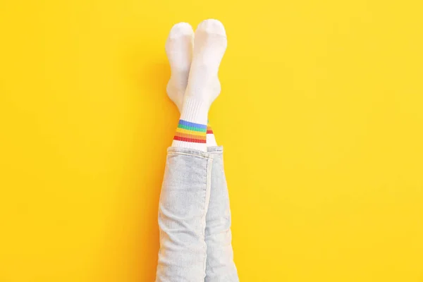若い女性の足で靴下とジーンズ上の色の背景 — ストック写真