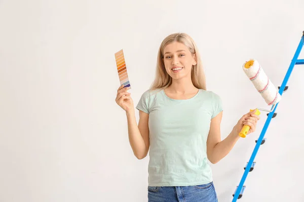 Mujer Joven Con Muestras Color Rodillo Pintura Sobre Fondo Blanco — Foto de Stock