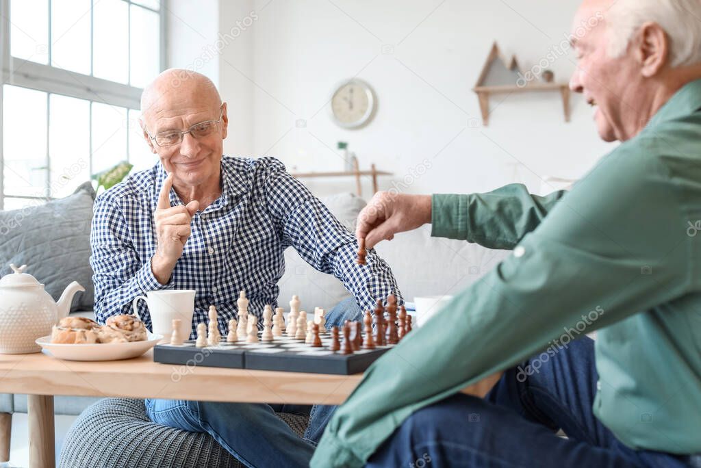 Elderly men playing chess at home