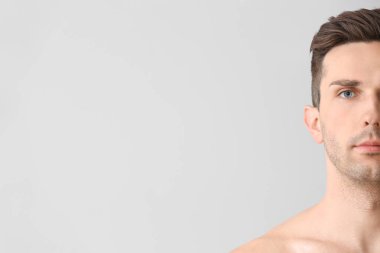 Hafif arka planda yakışıklı bir genç adam. Estetik ameliyat konsepti