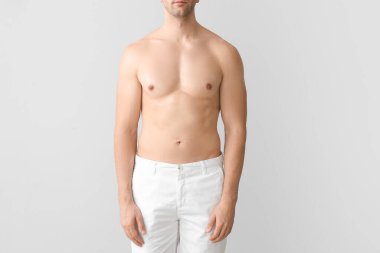 Hafif arka planda yakışıklı bir genç adam. Estetik ameliyat konsepti