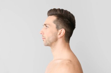 Hafif arka planda yakışıklı bir genç adam. Estetik ameliyat konsepti