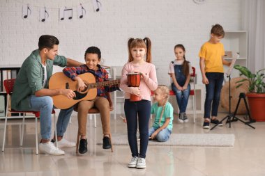 Teacher giving music lessons at school