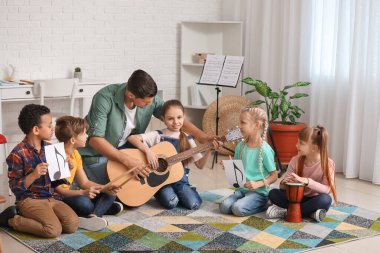 Teacher giving music lessons at school