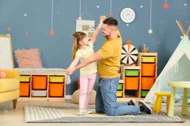 Father and his little daughter dancing at home