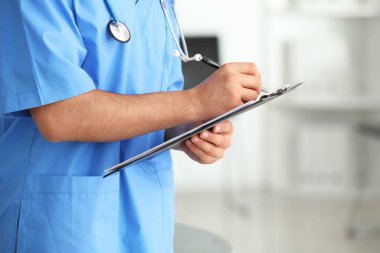 Klinikte belgeleri olan erkek doktor, yakın plan.