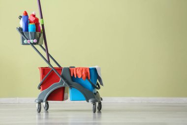 Renkli duvarın yanında temizlik malzemeleri var.