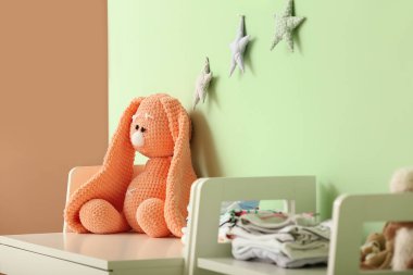 Çocuk odasındaki bebek elbiseleriyle sevimli bir oyuncak.