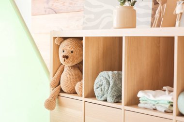 Evdeki raflarda bebek aksesuarları olan sevimli bir oyuncak.