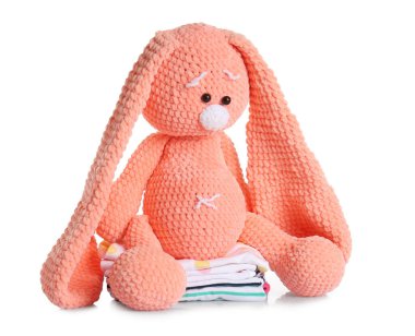 Beyaz arka planda bebek kıyafetleri olan sevimli bir oyuncak.