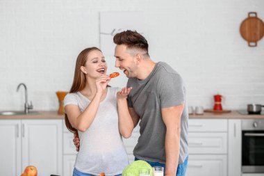 Mutfakta yemek pişiren mutlu genç çift.