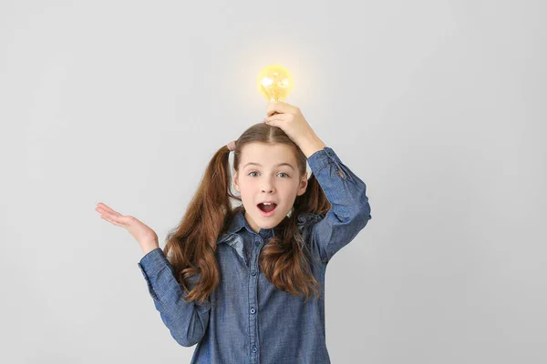 Cute Little Schoolgirl Glowing Light Bulb Grey Background — Stock Photo, Image