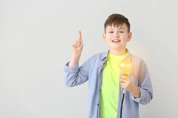 Söt Liten Skolpojke Med Glödande Glödlampa Grå Bakgrund — Stockfoto