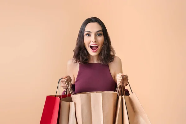 Überraschte Junge Frau Mit Einkaufstüten Auf Farbigem Hintergrund — Stockfoto