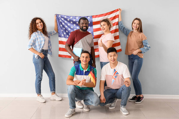 Young students of language school near light wall