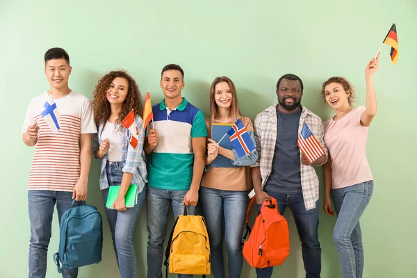 Young students of language school on color background