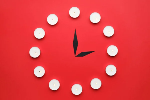 色の背景にキャンドルで作られた創造的な時計 — ストック写真