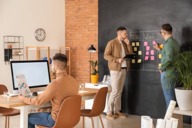 Ofiste çalışan bir grup adam.