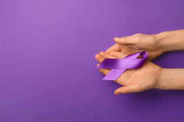 Renkli menekşe kurdeleli kadın eller. Aile içi şiddet kavramı