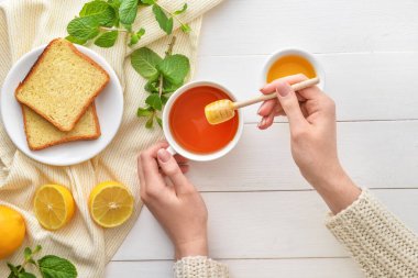 Masada ballı çay içen bir kadın.