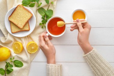 Masada ballı çay içen bir kadın.