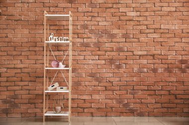 Tuğla duvarın yanında dekorlu şık raf ünitesi