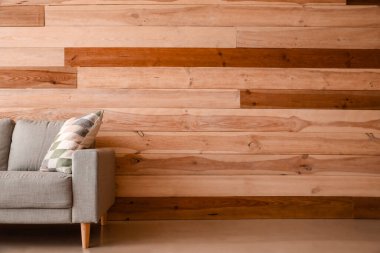 Ahşap duvarın yanındaki rahat kanepe.