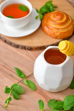 Lezzetli ballı çörek ve bir fincan çay.