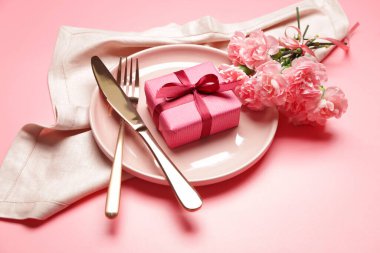 Arkaplanda hediyeler ve çiçekler olan güzel masa ayarları
