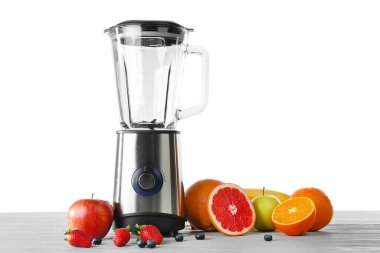 Masada beyaz arka planda sağlıklı meyve püresi için malzemelerle karıştırıcı