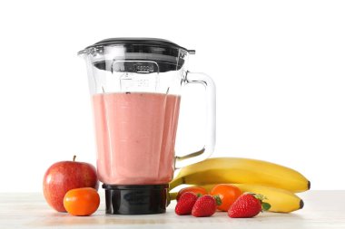 Masada beyaz arka planda sağlıklı meyve püresi için malzemelerle karıştırıcı