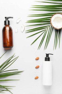 Beyaz arka planda şampuan, badem ve hindistan cevizi karışımı.