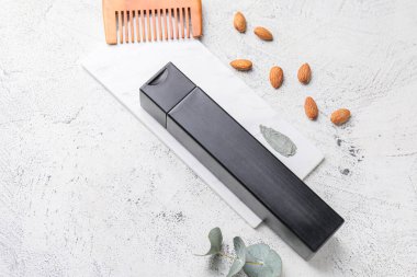 Açık arkaplanda şampuan, tarak ve doğal malzemelerle kompozisyon