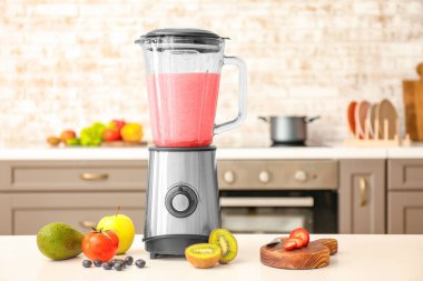 Mutfak masasında sağlıklı meyve suyu ile karıştırıcı.