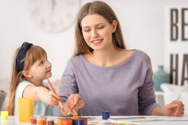 Çizim öğretmeni evde küçük bir kıza özel sanat dersleri veriyor.