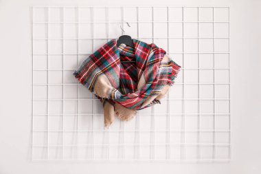 Beyaz duvarda güzel bir eşarp asılı.