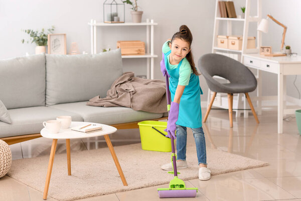 Little housewife cleaning floor at home