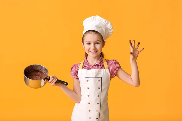 Маленькая Домохозяйка Расплавленным Шоколадом Кастрюле Цветном Фоне — стоковое фото