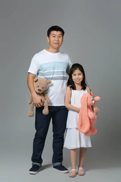 Glad Asiatisk Man Och Hans Lilla Dotter Med Leksaker Grå — Stockfoto