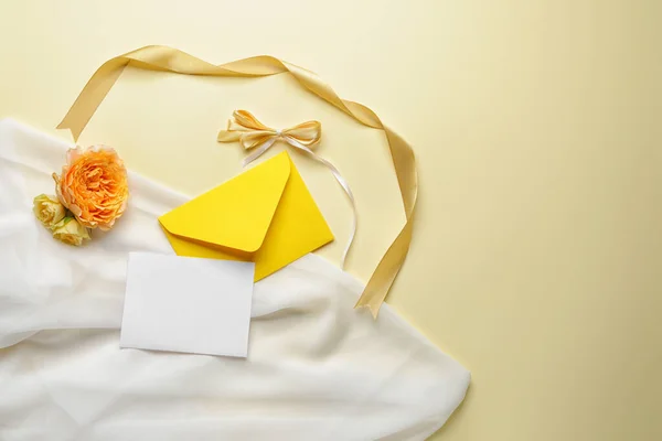Composition with empty greeting card and envelope on color background